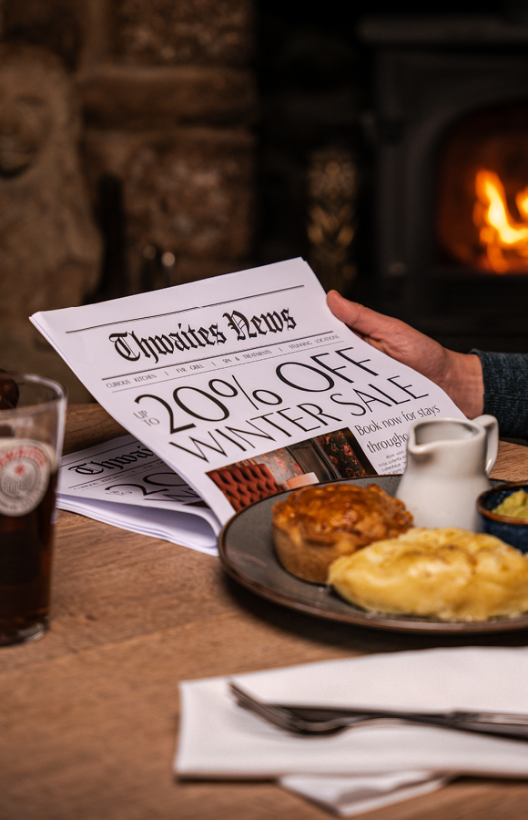 "up to 20% off this winter" newspaper with a pie and a pint at a pub table